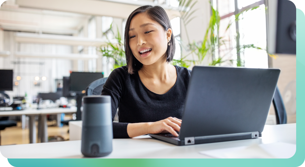 Woman speaking to smart speaker at work