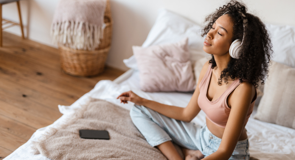 Woman at home using meditation app listening to meditation music to relax