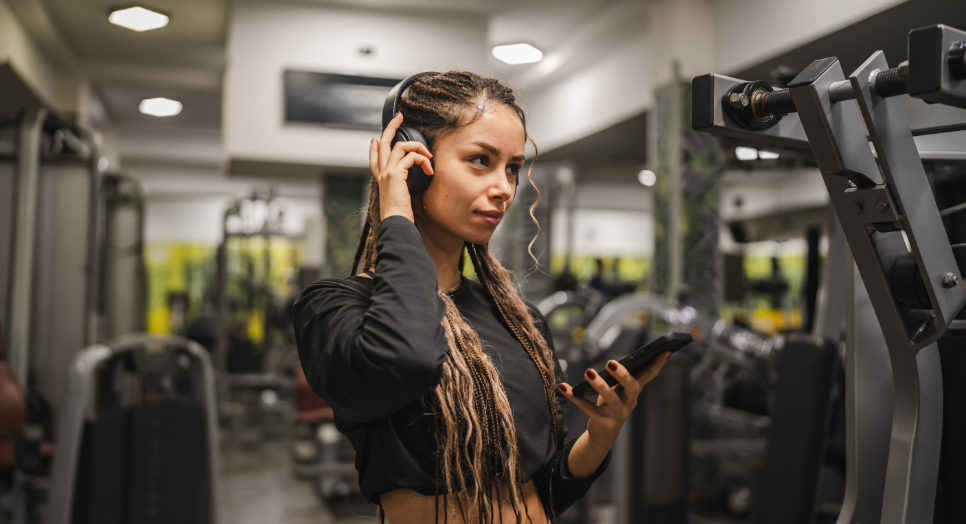 Woman athlete using sports app listening to music in sports tech