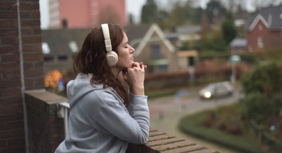 woman praying using christian app listening to music on headphones